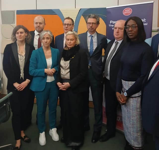 Daisy Cooper MP standing with a group of MPs, after meeting with the Post Office HQ in Parliament.